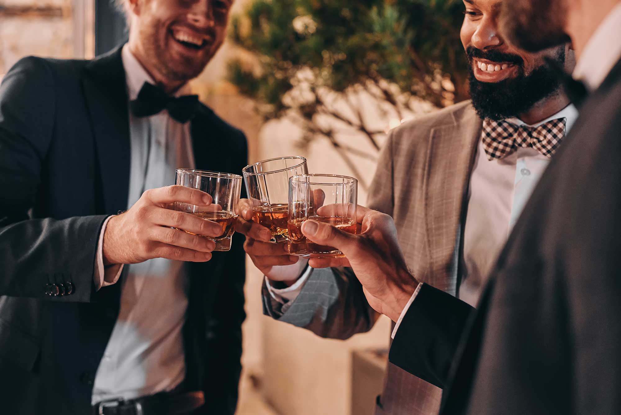 close up of three well dressed men drinking whiskey